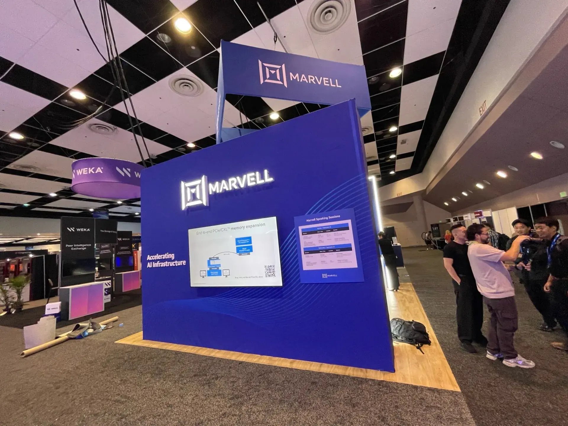 Marvell exhibit wall with an illuminated logo, a CXL memory expansion demo screen and a speaking sessions board