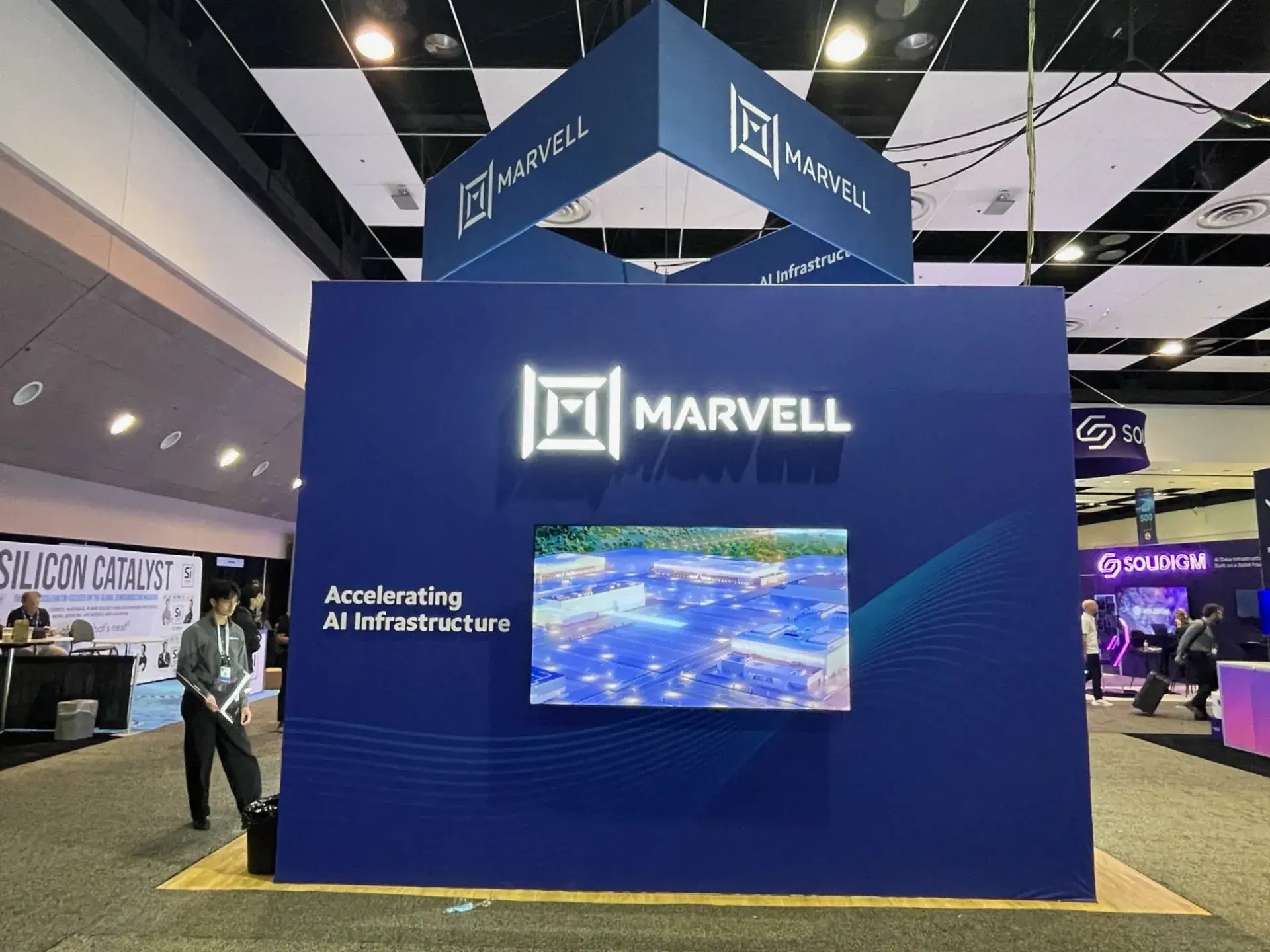 Exterior wall of the Marvell exhibit with an illuminated logo and a large-format display under the hanging sign