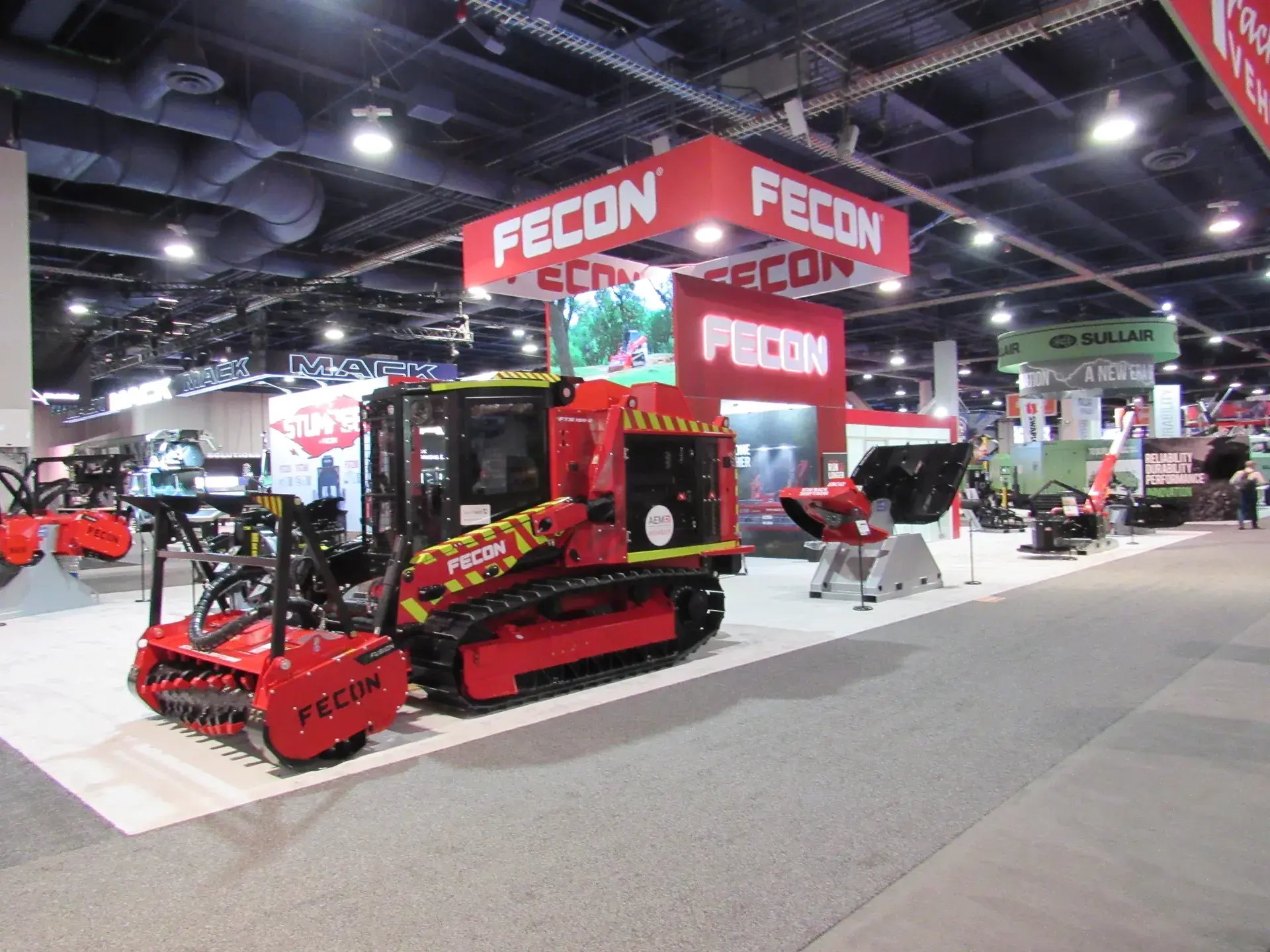 Overview of the Fecon ConExpo island exhibit with land-clearing equipment and overhead branding