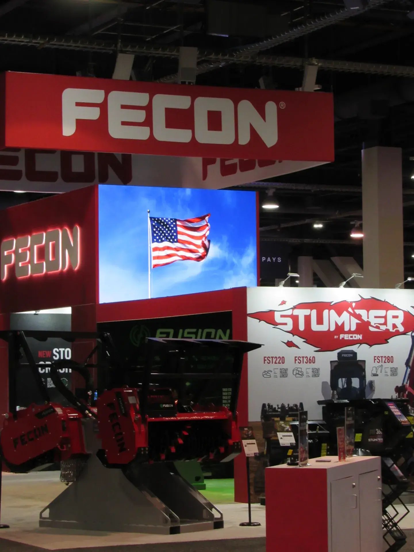 Fecon Stumper machine beside an LED video wall on the ConExpo show floor
