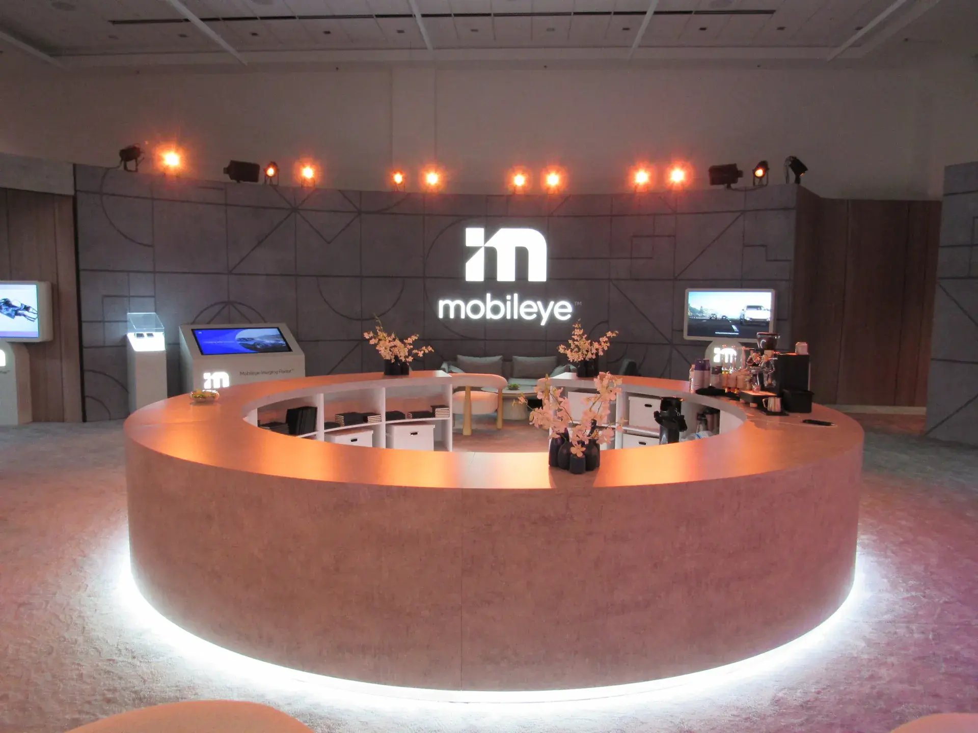 Custom circular hospitality coffee bar with accent under-lighting inside the branded meeting room environment