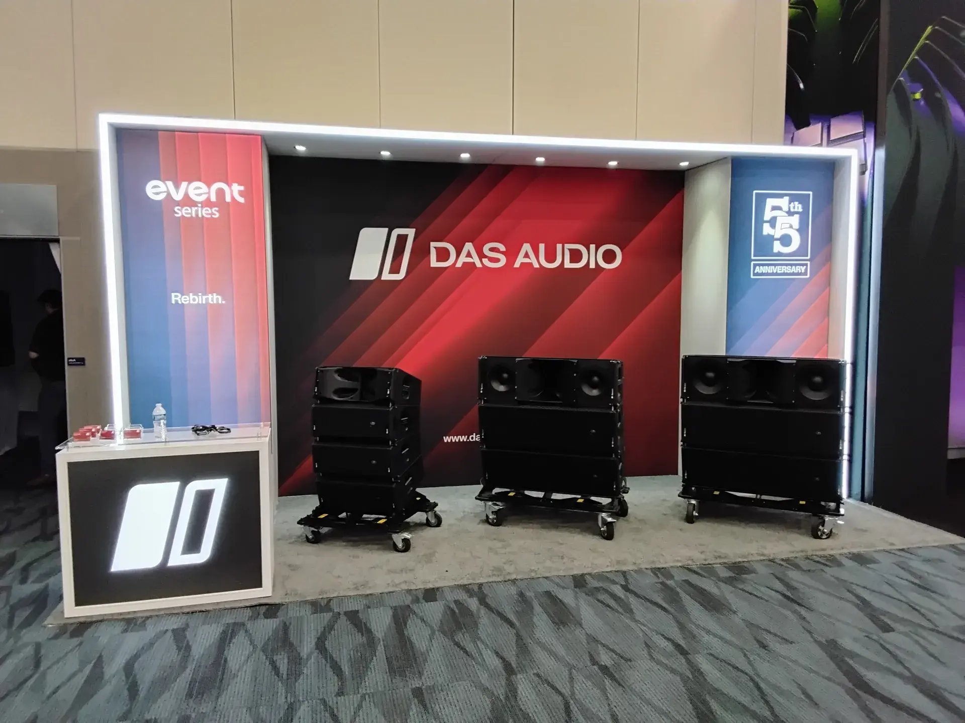 Product demonstration area with branded backdrop and professional audio equipment display