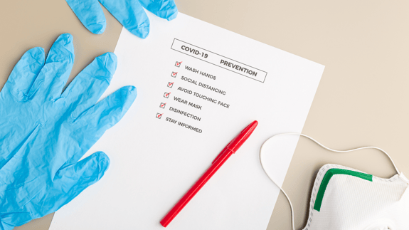 A tradeshow safety checklist with latex gloves and a mask 