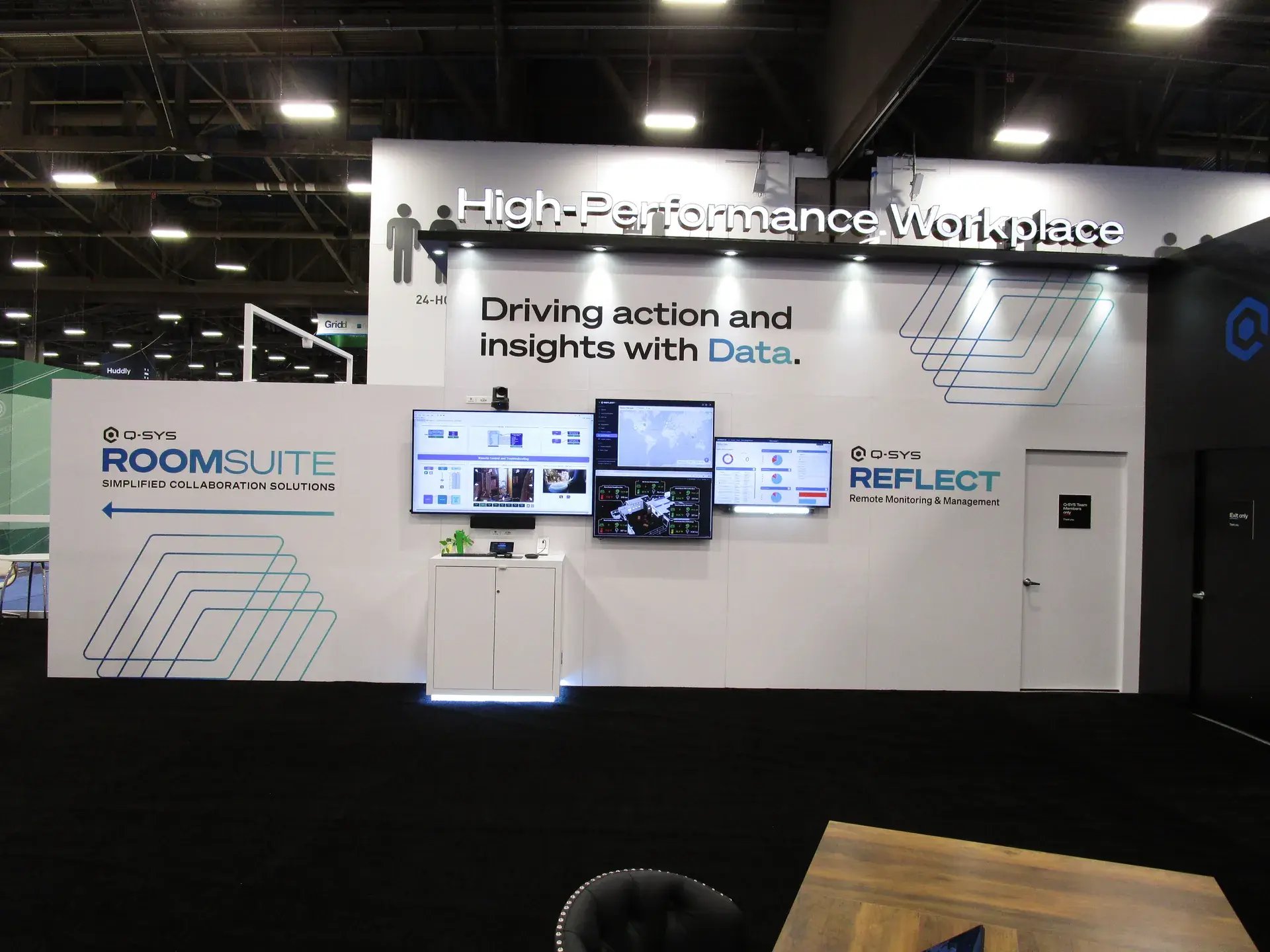 Q-SYS Sportsbook experiential zone with walnut finishes, hospitality tables and sports video displays