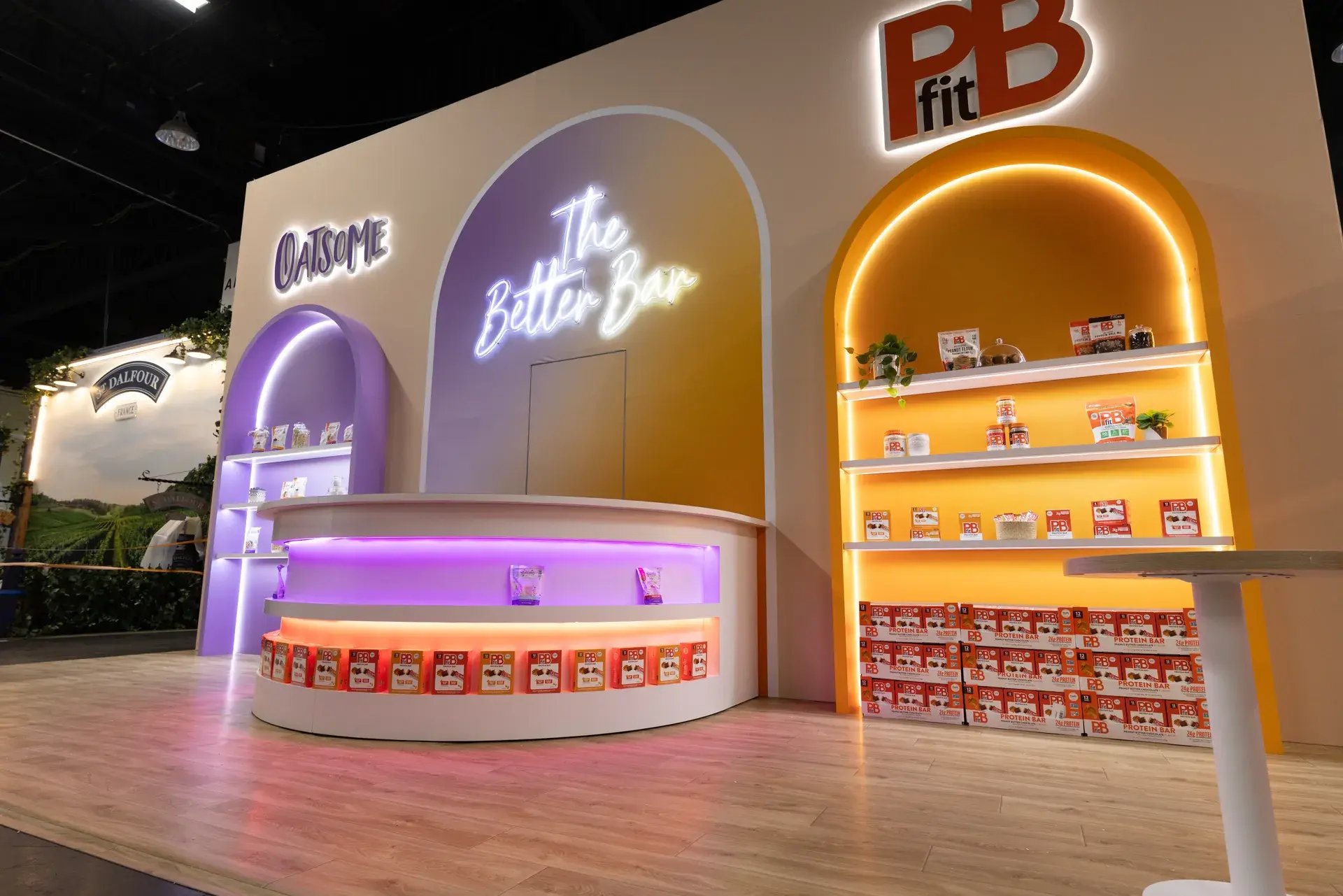 Illuminated The Better Bar wall and curved hospitality counter at the BetterBody Foods exhibit