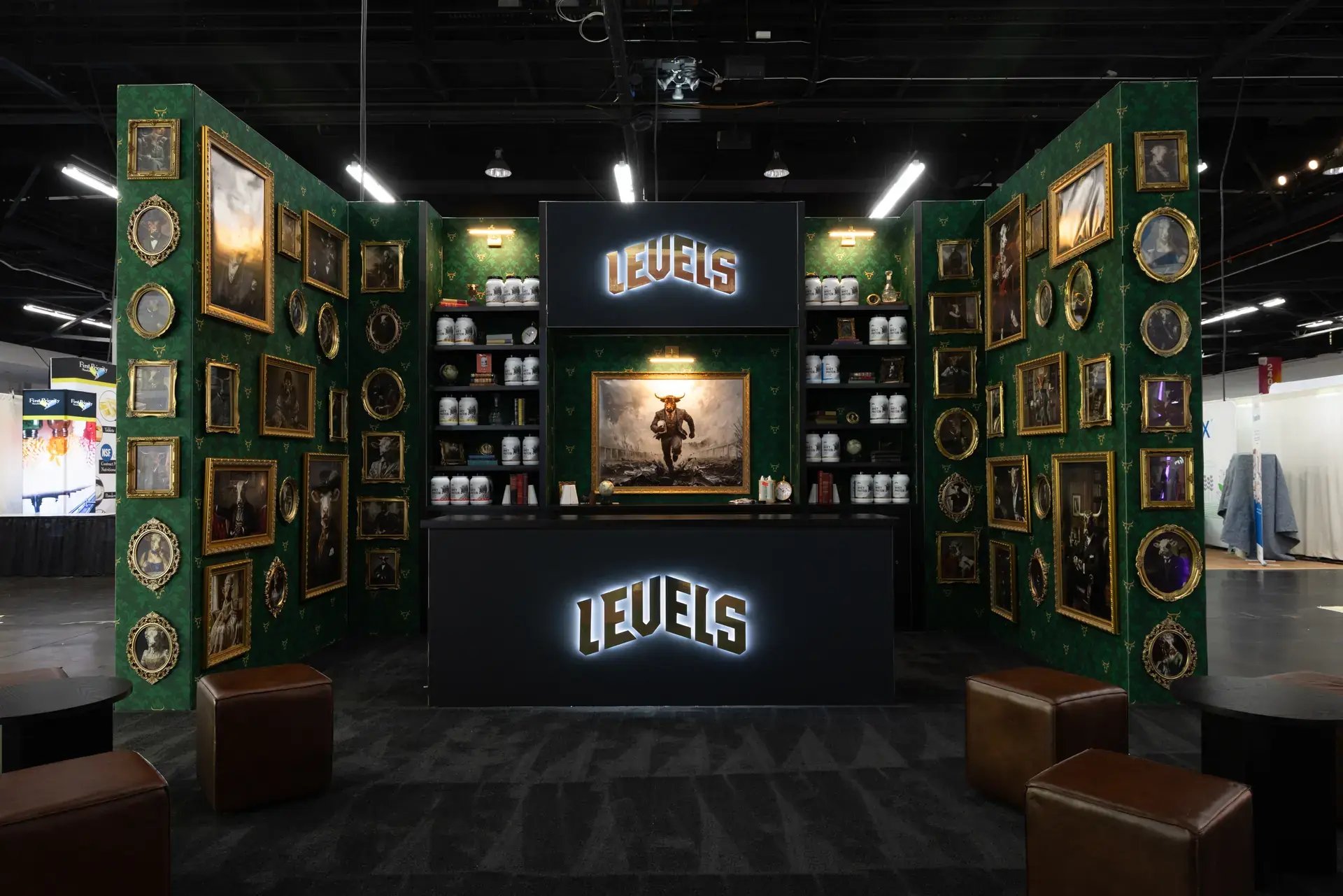 LEVELS 20x20 island exhibit at Natural Products Expo West with emerald gallery walls, gold-framed portraits and halo-lit logos